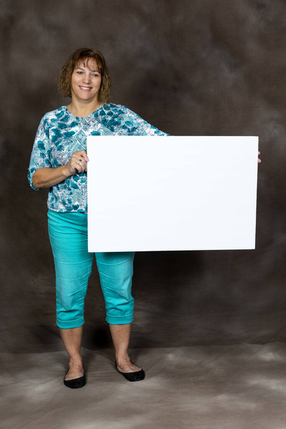 Happy or Friendly Middle-aged Woman Holding Blank Sign - Фото, изображение