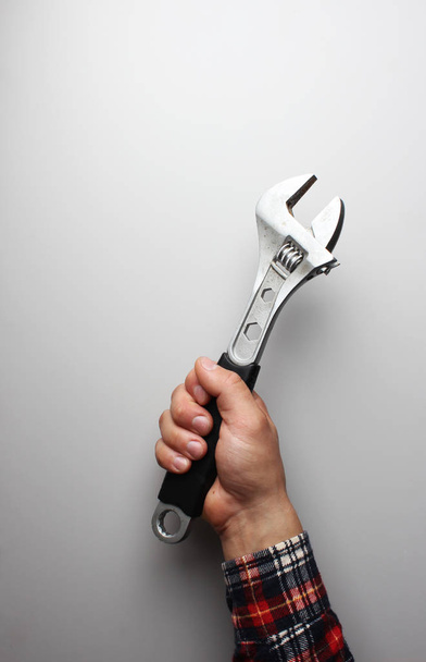 wrench in hand on a gray background - Zdjęcie, obraz