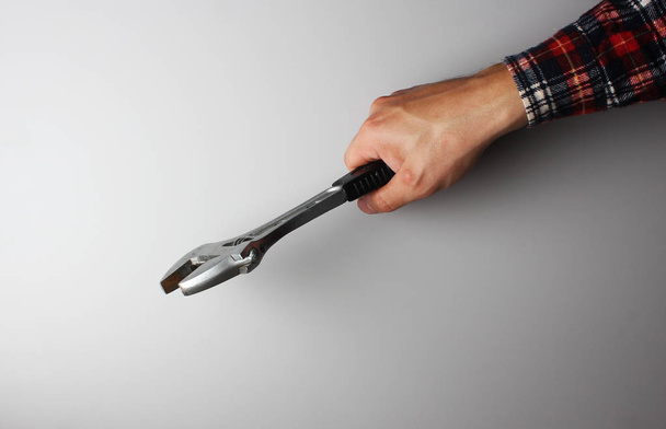 wrench in hand on a gray background - Zdjęcie, obraz