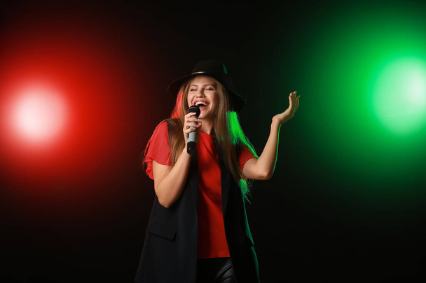 Linda jovem cantora com microfone no palco
 - Foto, Imagem