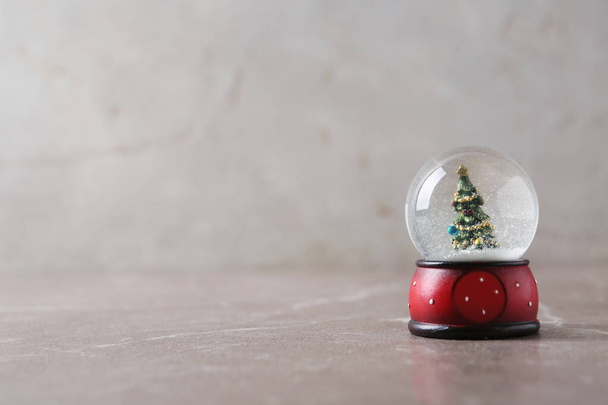 Snow globe with Christmas tree on marble table, space for text - Photo, Image