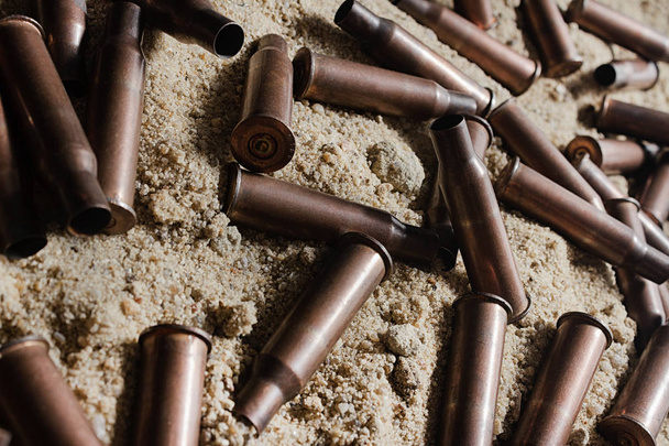 Montón de proyectiles de rifle colocados en la arena
. - Foto, imagen