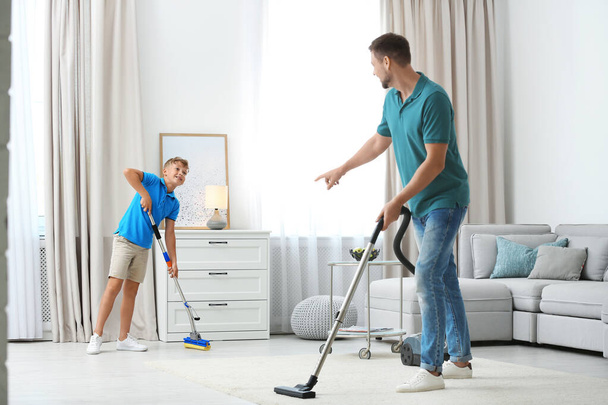 Dad and son cleaning living room together - Photo, image