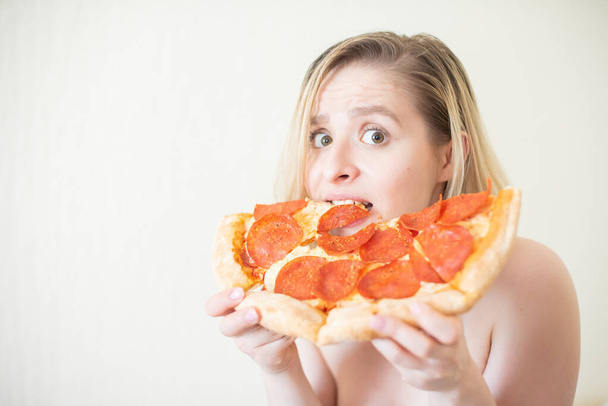 European girl with short hair posing with pieces of delicious pizza. - Photo, image