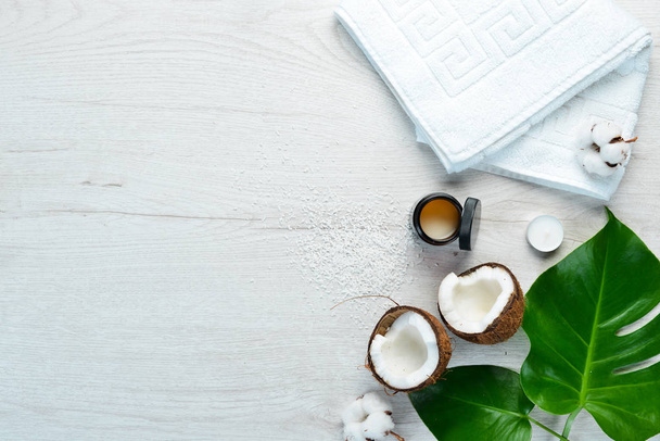 Cosmetics based on coconut and tropical leaves. On a white wooden background. Flat lay. - Foto, immagini