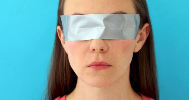Femme avec les yeux collés avec une bande de cire
 - Photo, image