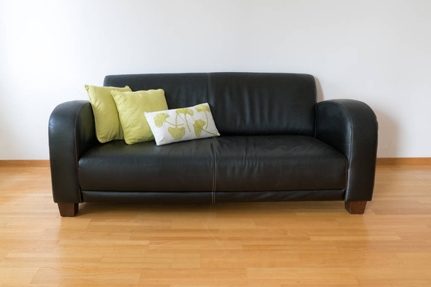 vista orizzontale di un divano in pelle marrone scuro con tre cuscini
 - Foto, immagini
