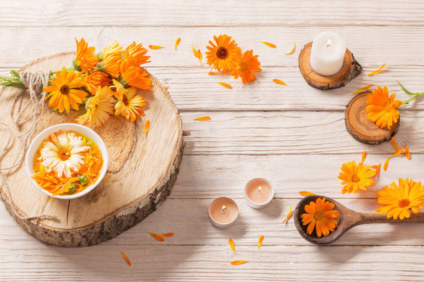  Medicinal flowers of calendula on white wooden background - Foto, imagen
