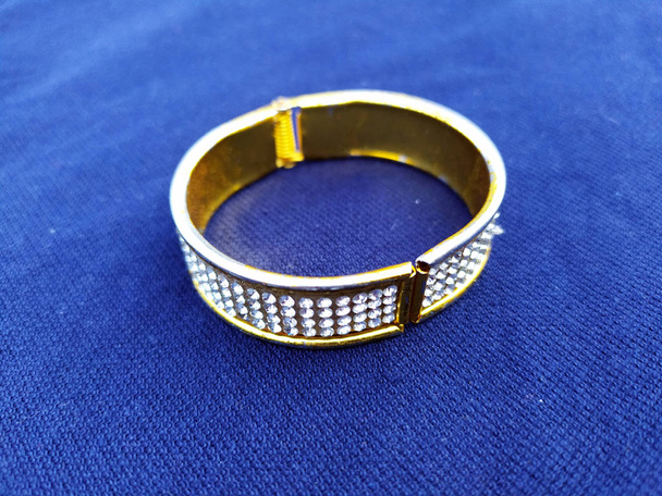 Mavi arkaplanda altın elmas bilezik izole edildi - Fotoğraf, Görsel