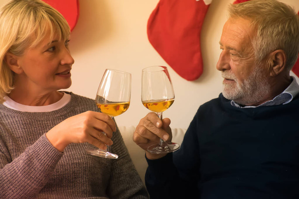 Старша пара п'є вино. Щаслива старша пара святкує свято щастя. Старі пари святкують Різдво
. - Фото, зображення