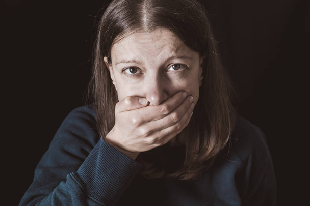 Vrouw met handen gesloten mond. Vrouwelijk geweld concept. Beperking en onvermogen om te spreken. - Foto, afbeelding