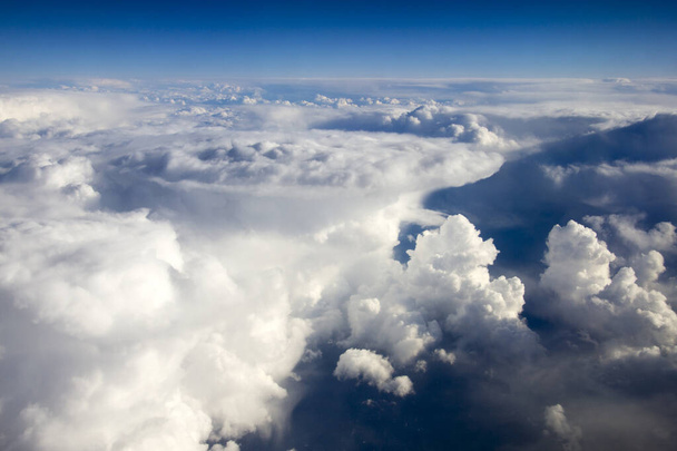 Вид с воздуха с самолета на горы, покрытые облаками
 - Фото, изображение