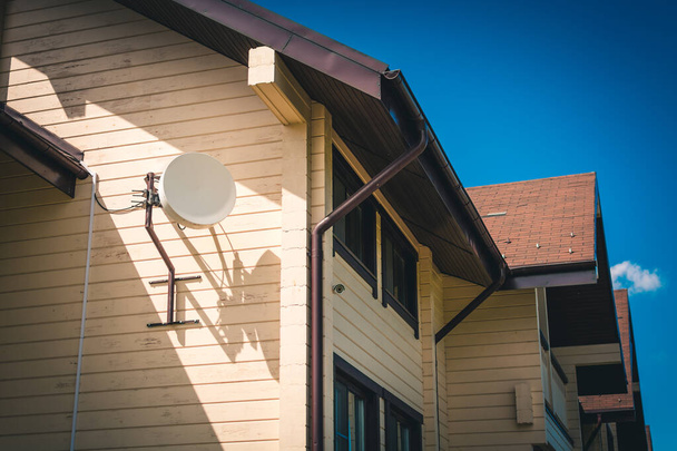 Round antenna for transmitting signal to TV on the roof of the house. - Valokuva, kuva