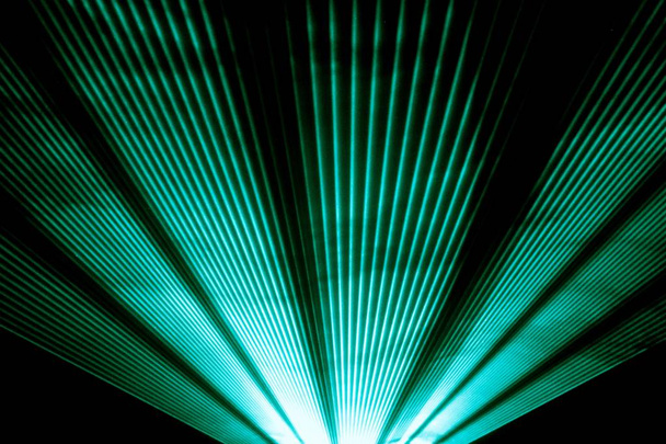 Бирюзовое лазерное шоу на сцене ночного клуба, сияющее сверкающими лучами
 - Фото, изображение