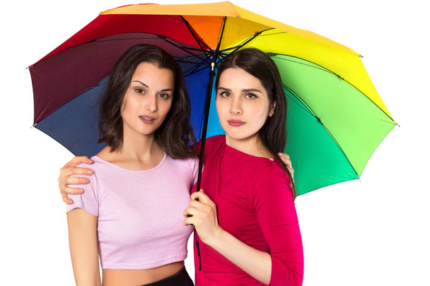 Dvě mladé atraktivní ženy pod jedním deštníkem - Fotografie, Obrázek