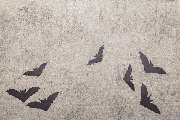 Halloween decoratie concept - zwarte vleermuizen op grijze steen beton achtergrond - Foto, afbeelding