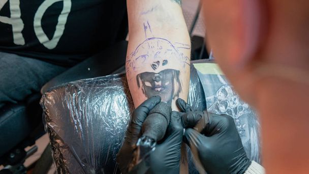 Επαγγελματίας καλλιτέχνης τατουάζ κάνει ένα τατουάζ σε ένα νεαρό άνδρα "s han - Φωτογραφία, εικόνα