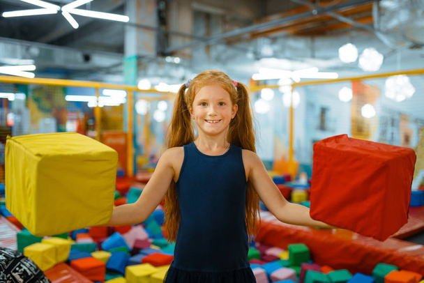 Adorabile bambina che gioca con morbidi cubi, parco giochi nel centro di intrattenimento. Area giochi all'interno, sala giochi
 - Foto, immagini