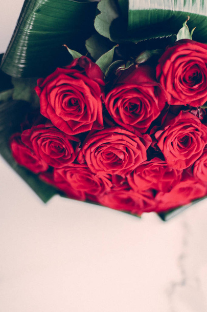 Luxus csokor vörös rózsa márvány háttér, gyönyörű áramlás - Fotó, kép