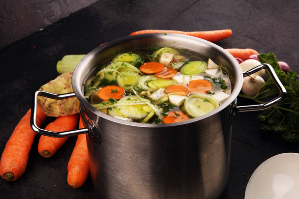 Caldo con zanahorias, cebollas varias verduras frescas en una olla - c
 - Foto, imagen