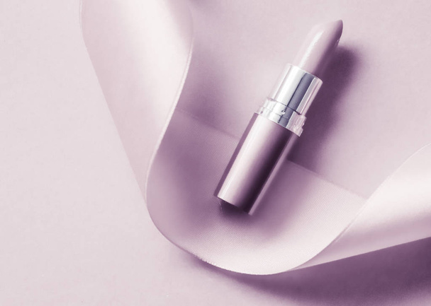 Luxe lippenstift en zijden lint op blush paarse vakantie backgrou - Foto, afbeelding