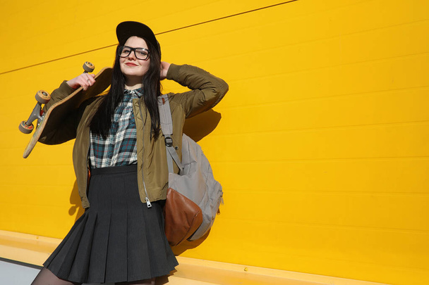 Una joven hipster está montando un monopatín. Chicas novias f
 - Foto, imagen