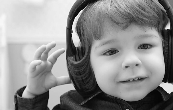 kisgyerek zenét hallgat fejhallgatóban, fekete-fehér fotó - Fotó, kép