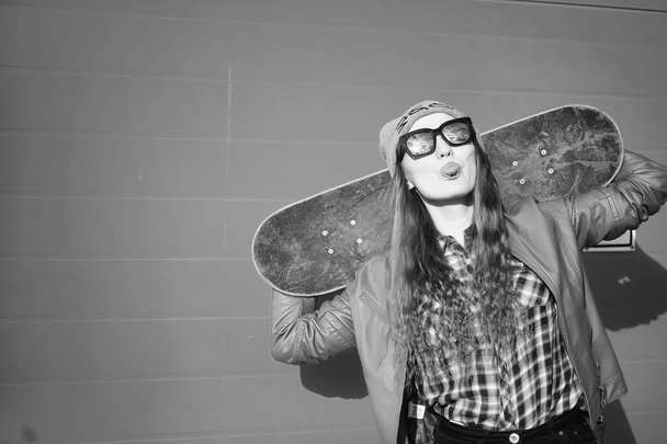 Una joven hipster está montando un monopatín. Chicas novias f
 - Foto, imagen