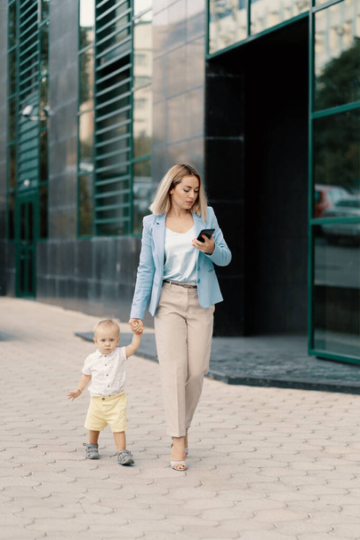 Ritratto di una donna d'affari di successo in abito blu con bambino
 - Foto, immagini