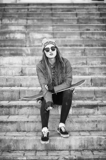 A young hipster girl is riding a skateboard. Girls girlfriends f - Photo, Image