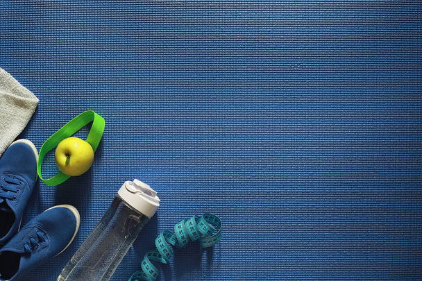 Στρώμα για εξάσκηση γιόγκα στο πάτωμα. Υγιής τρόπος ζωής. - Φωτογραφία, εικόνα