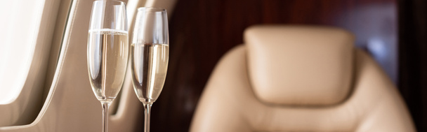 panoramisch shot van champagne glazen in prive jet  - Foto, afbeelding