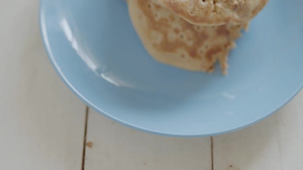handheld camera. gluten free pancakes on blue dish for healthy breakfast. top side view of white wooden table with ingredients for breakfast - 映像、動画