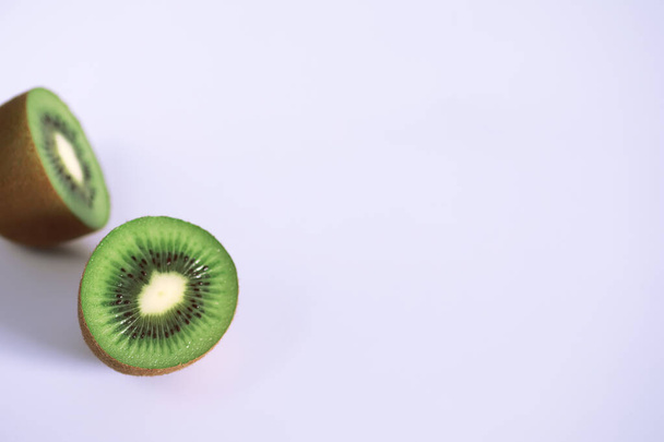 A kiwi fruit is sliced on a white background - Fotografie, Obrázek