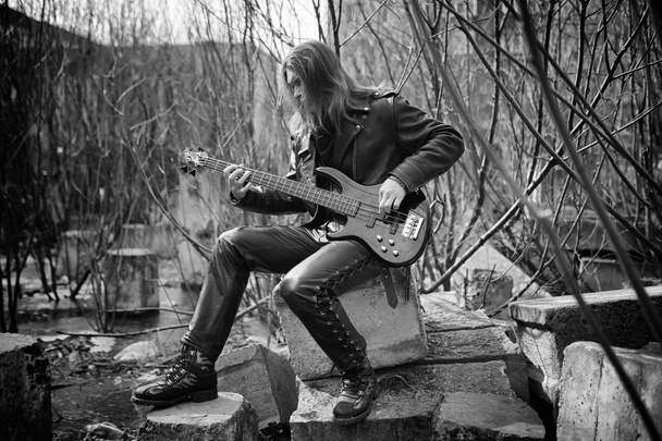 屋外のロック ギタリスト。Leath でベースギターを持つ音楽家 - 写真・画像