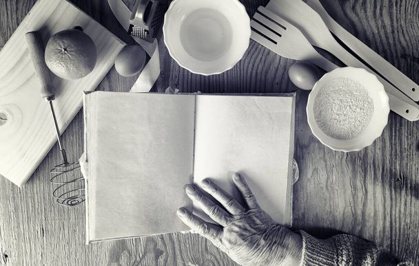 Recipe book in the hands of an elderly woman - Фото, зображення