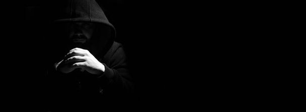 Un hombre con capucha negra y puños
 - Foto, Imagen