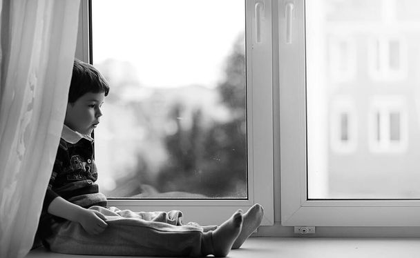 El niño está leyendo un libro. El niño se sienta en la ventana a
 - Foto, Imagen