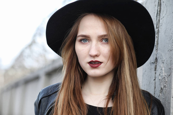 Young beautiful girl in a hat and with a dark make-up outside. G - Foto, imagen