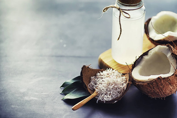 Coconut on a dark stone table. Coconut oil. - Photo, Image