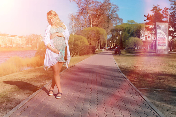 公園での散歩に妊娠中の女の子。Ci の腹を持つ少女 - 写真・画像