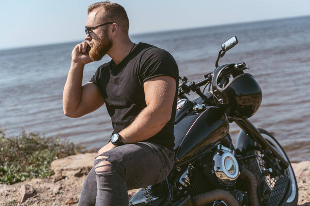 Side view of a handsome muscular man talking on the phone - Valokuva, kuva