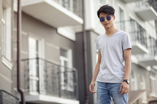 Asiatico giovane uomo indossare occhiali da sole all'aperto
 - Foto, immagini
