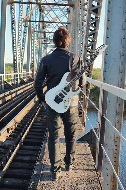 Homme avec une guitare électrique dans le paysage industriel extérieur
 - Photo, image
