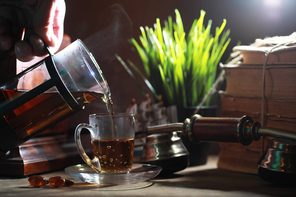 Brewing tea on a wooden table - Foto, afbeelding