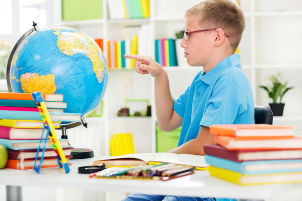 Niño estudiando geografía con globo
 - Foto, imagen
