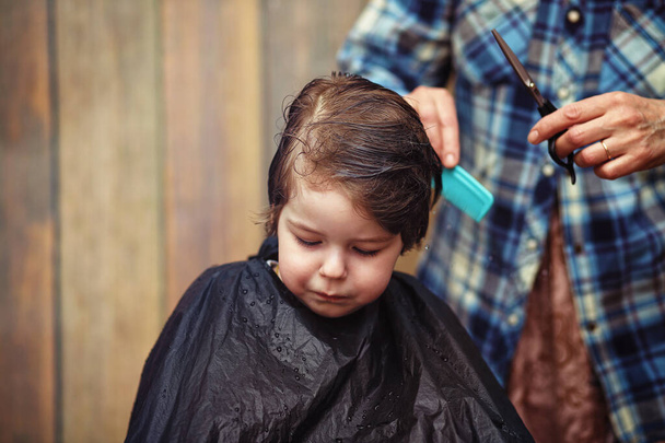 Ein kleiner Junge wird im Friseursalon getrimmt  - Foto, Bild