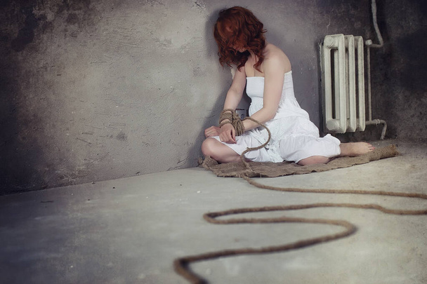 Young girl tied up on the floor. The abducted girl. The victim o - Photo, Image