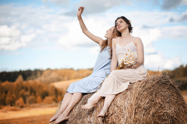 Две девушки в платьях на осеннем поле
 - Фото, изображение