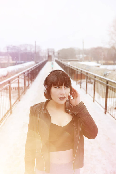 Girl in headphones listening to music outdoors - Foto, afbeelding